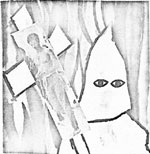 person dressed as KKK
member, holding a cross with a photo of Hekima Ana on it